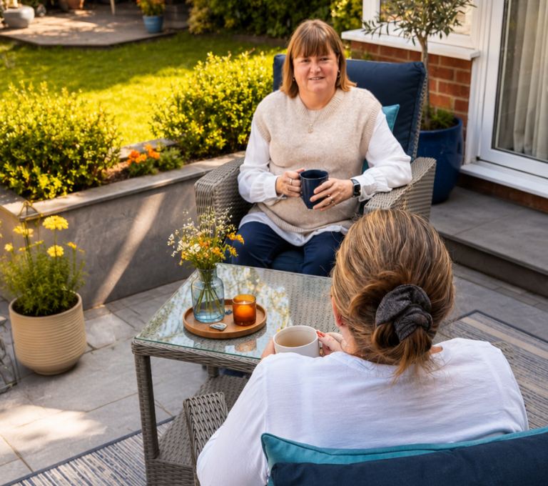 Contact Counsellor and client talking over coffee in a peaceful garden setting